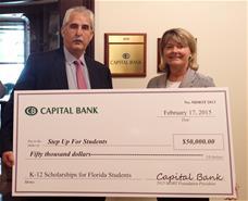 Capital Bank Market President Edward Holden presents the company's contribution to Step Up For Students Development Officer Renae Sweeney