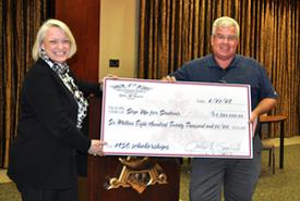 Jody Hysler, SUFS director of operational compliance, joins Hugh Shields, Gold Coast Eagle marketing manager, to accept Gold Coast Eagle’s $6.82 million contribution to the scholarship program.