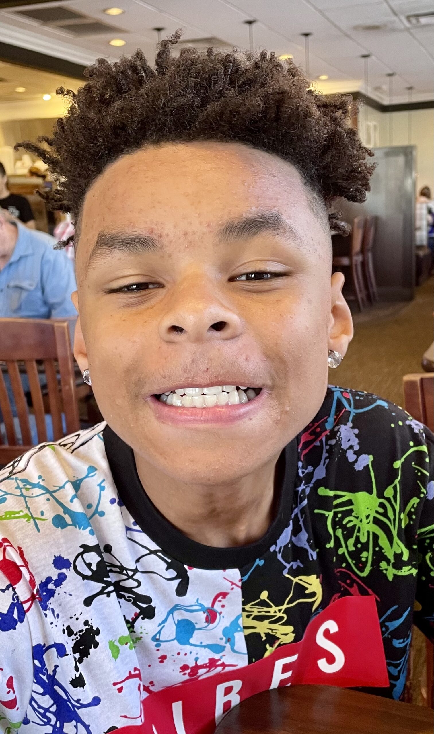 foto de un joven afroamericano sonriendo con los dientes a la cámara